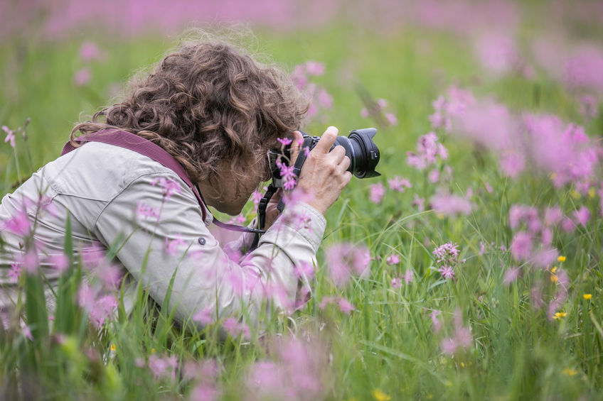 Mujer haciendo fotos en el campo